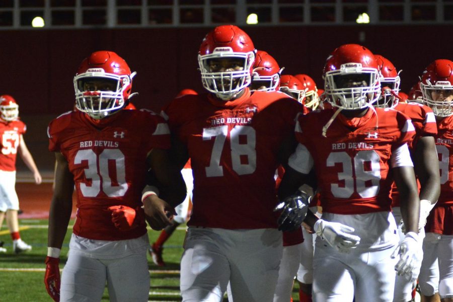 Leading their team onto the field arm in arm, senior captains Anthony Hugee, Arnold Young and Maurice Obanor basked under the Friday night lights in their final game against Moorestown.