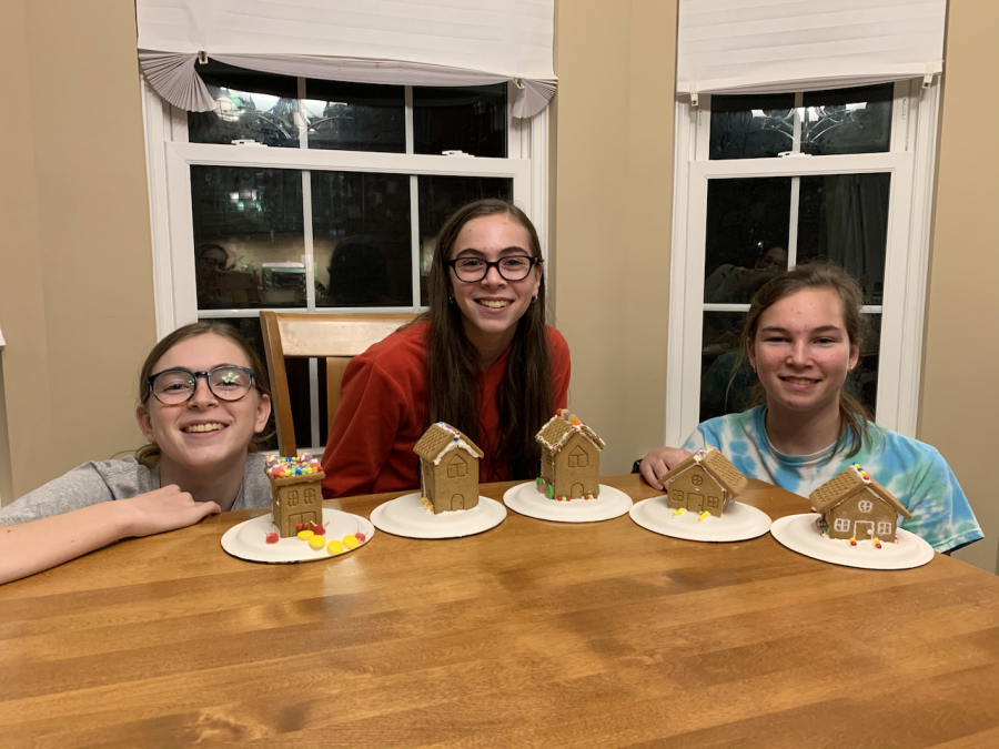 Senior Emily Paulin (far right) with sisters (from left to right) Sarah and Natalie make gingerbread houses