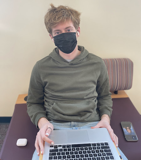 Senior, Lucas Miglin, wearing a mask in the library