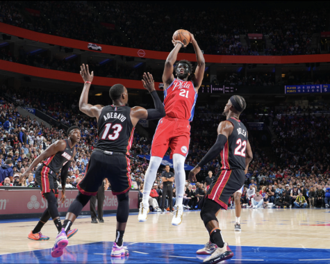 Joel Embiid of the Sixers takes a shot against Heat defenders on Sunday night