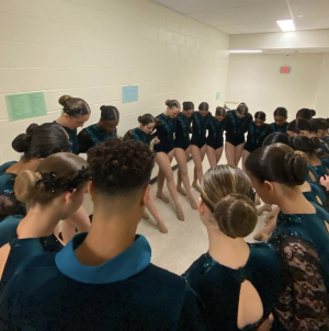 The Dance Team huddles before their January Reach for the Stars performance