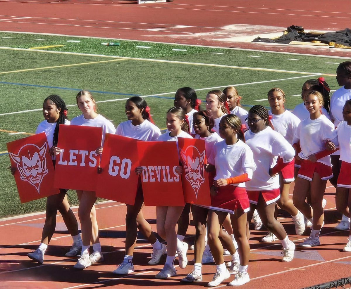 RV's cheerleaders walking the track at the homecoming pep rally. 